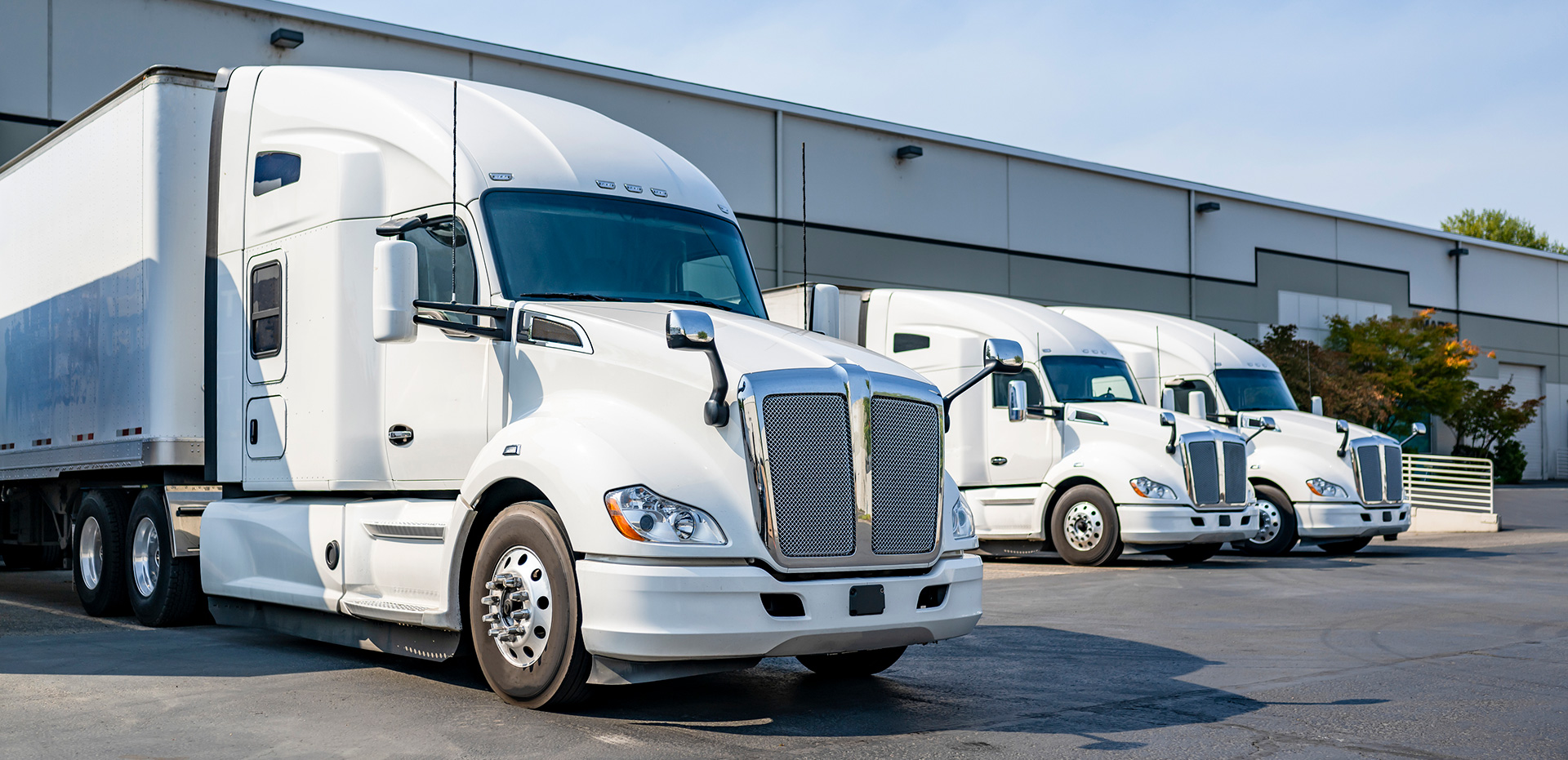 White Semi Trucks parked at warehouse